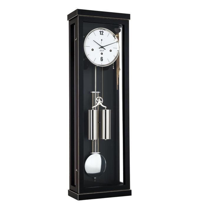 Black wall clock with dual weights and pendulum on a white background