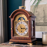 Decorative clock on marble dresser with picture of boat behind