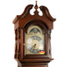 Up close view of cherry wood Grandmother clock with silver face and intricate moon dial 