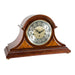 Cherry wood mantle clock with detailed face and holes for winding the mechanical movement inside on white background
