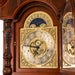 Close-up of brass clock face with ornate details on cherry wood grandfather clock.