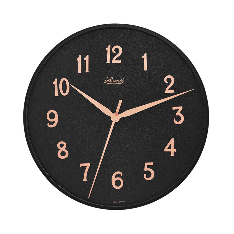 Wall clock with black face and gold numbers on white background.