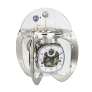 Silver astronomical clock with visible intricate movement and planet gears beneath glass dome on white background.