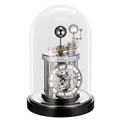 Decorative black clock with mechanical components under a glass dome on a white background
