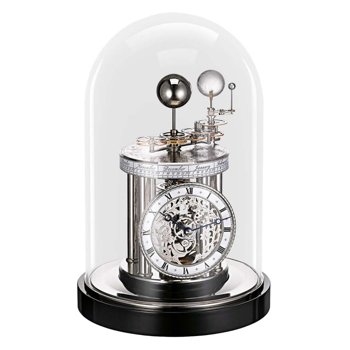 Decorative black clock with mechanical components under a glass dome on a white background