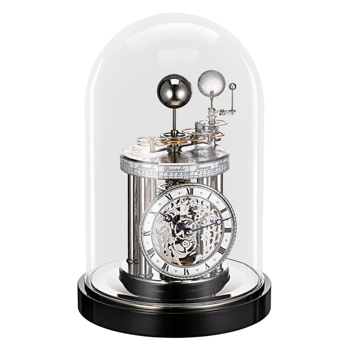 Decorative black clock with mechanical components under a glass dome on a white background