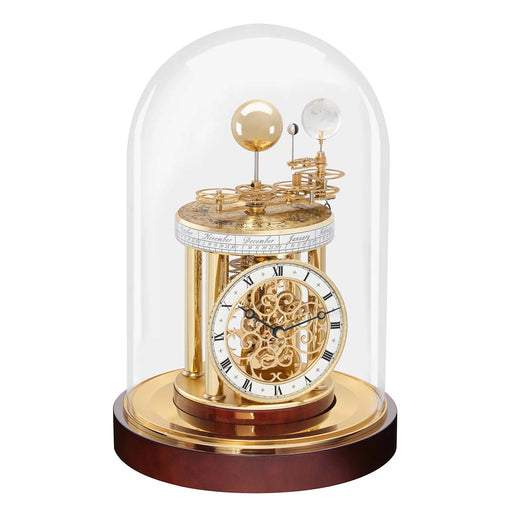 Decorative mahogany clock with mechanical components under a glass dome on a white background