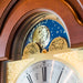 Moon phase dial close up on wooden grandfather clock with brass face 