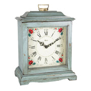 Blue decorative clock with floral design on a white background