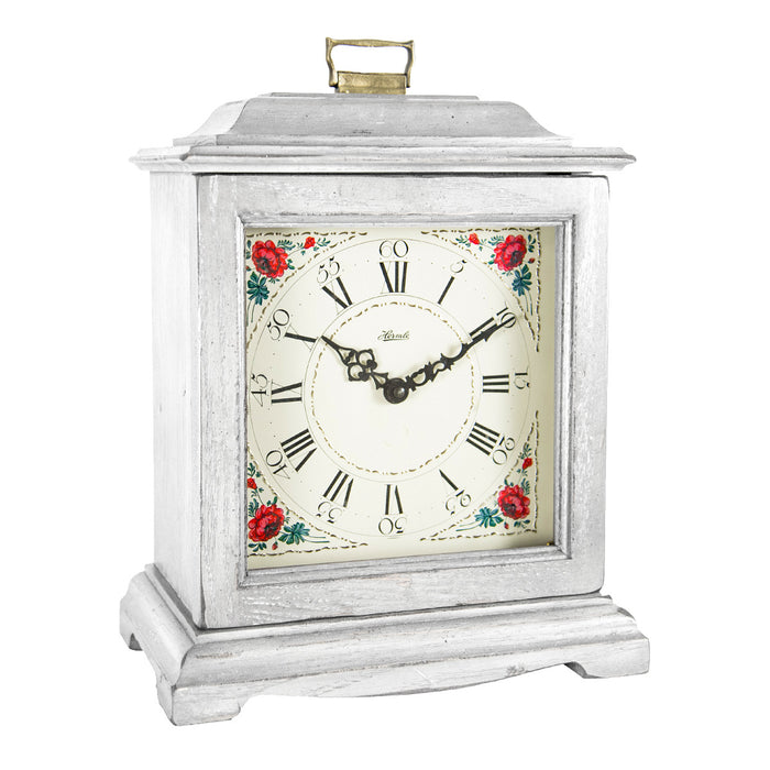 White decorative clock with floral design on a white background