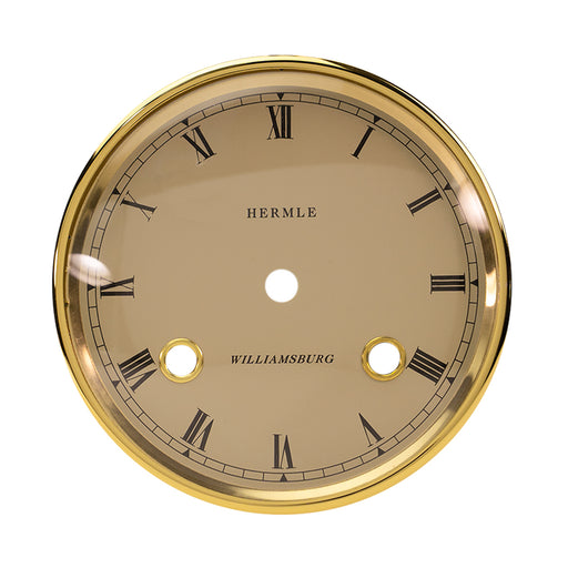 Brass rimmed dial with cream face and Roman Numerals on white background. 