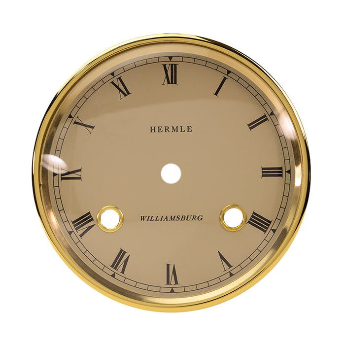 Brass rimmed dial with cream face and Roman Numerals on white background. 