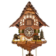 Close up of wooden cuckoo clock with 'Made in Germany' on the face and bear figurines next to pine tree.