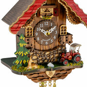 Close-up of German cuckoo clock with red tractor and young deer.
