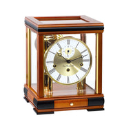 Light cherry wood mantel clock with brass face and glass sides on white background.