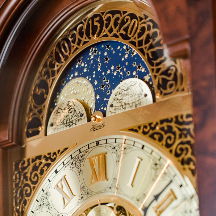 Close-up of an ornate clock face with starry sky design and Roman numerals.