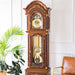 Wooden grandfather clock with brass highlights in white room next to green plant and leather chair 