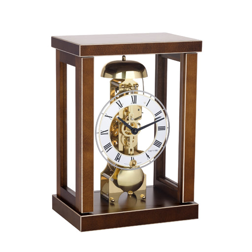 Walnut wood mantel clock with glass sides and visible brass gears and bell, roman numeral face.