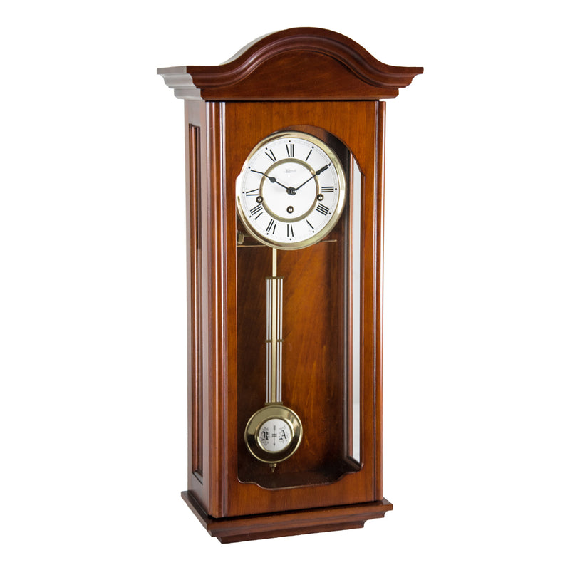 Cherry wood wall clock with brass pendulum on a white background