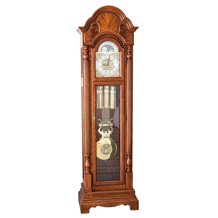 Wooden grandfather clock with brass highlights and pendulum on a white background