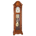 Wooden grandfather clock with brass highlights and pendulum on a white background