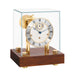Light cherry desk clock with glass case and silver clock face with brass highlights on white background