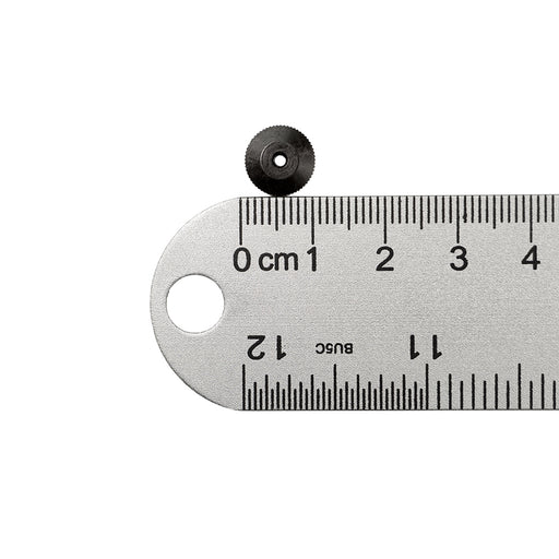 Black hand nut next to ruler showing one centimeter measurement on white background. 
