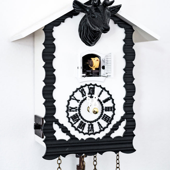 Up close of black and white cuckoo clock with cuckoo bird coming out of door 
