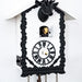 Up close of black and white cuckoo clock with cuckoo bird coming out of door 