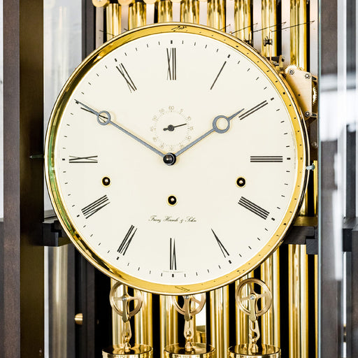 Close up of roman numeral clock face with brass highlights and seconds display