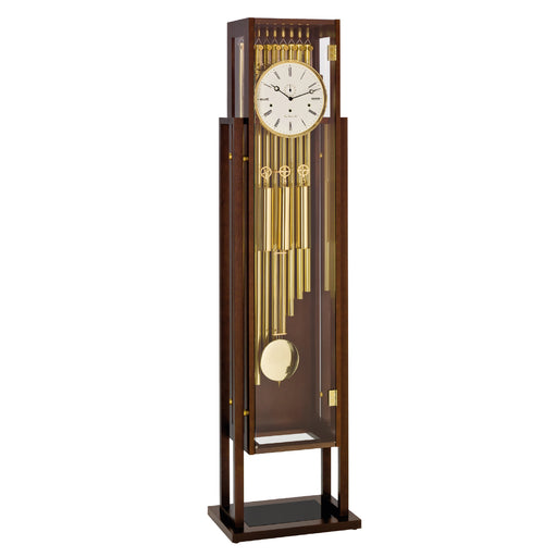 Tubular floor clock with brass highlights and white face on white background