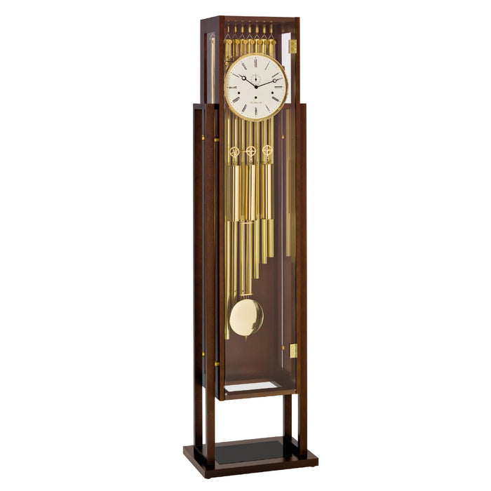 Tubular floor clock with brass highlights and white face on white background
