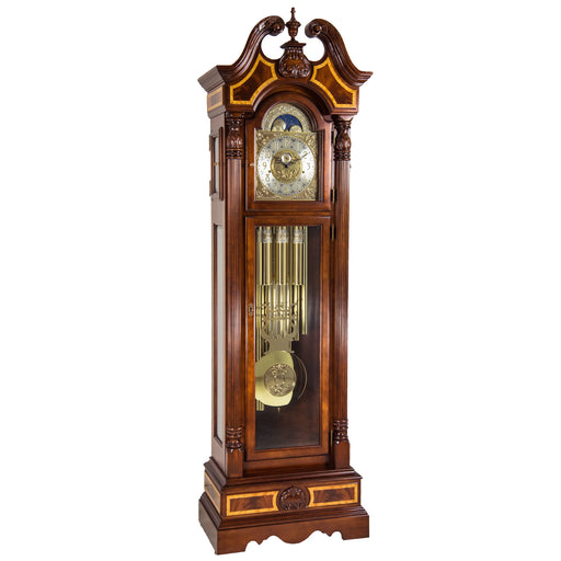 Wooden grandfather clock with intricate design, tubular chime movement and brass face on a white background