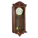 Intricate wooden wall clock with brass highlights and holes on the face for winding the mechanical movement inside