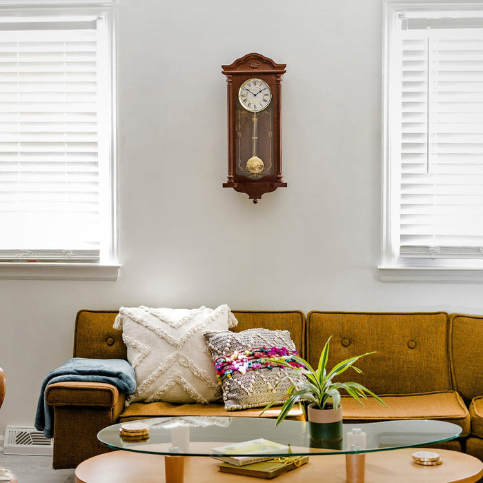 Detailed wooden wall clock hanging above sofa in living room 