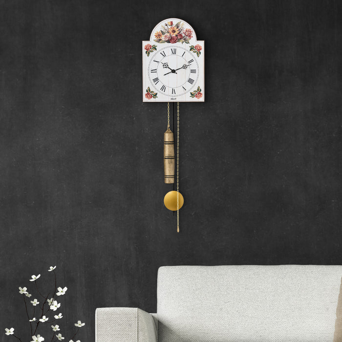 Floral pattern wall clock with brass pendulum hanging on gray wall above sofa in living room.