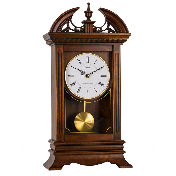 wooden mantel clock with decorative elements on top, and brass pendulum below.