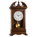 wooden mantel clock with decorative elements on top, and brass pendulum below.