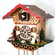 Close up of detailed cuckoo clock with wooden roman numeral face and small owl figures
