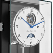 Luxury watch with intricate design and visible Franz Hermle and Sohn brand name in a clear display case.