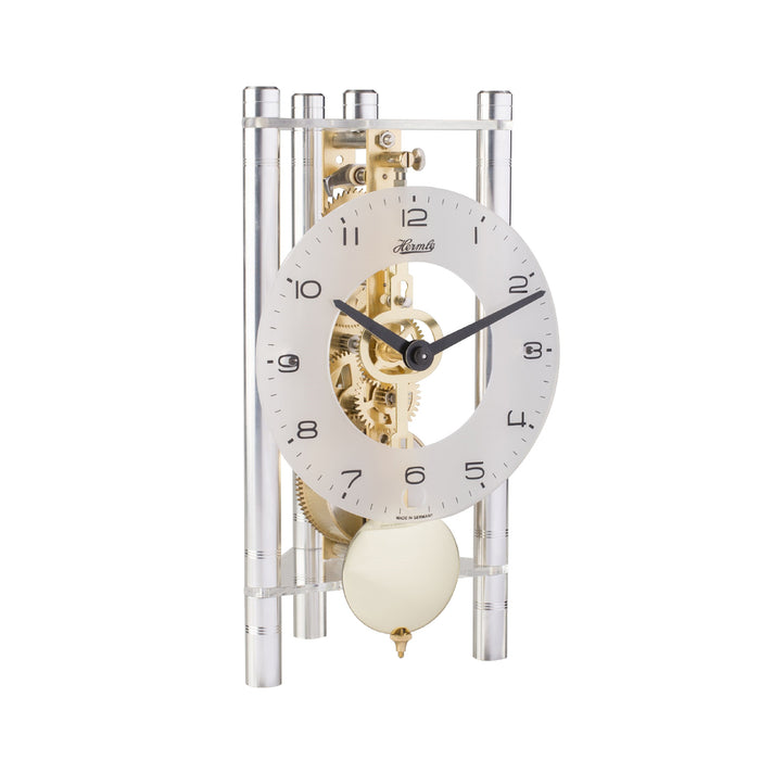 Silver and brass mechanical clock with glass face on white background