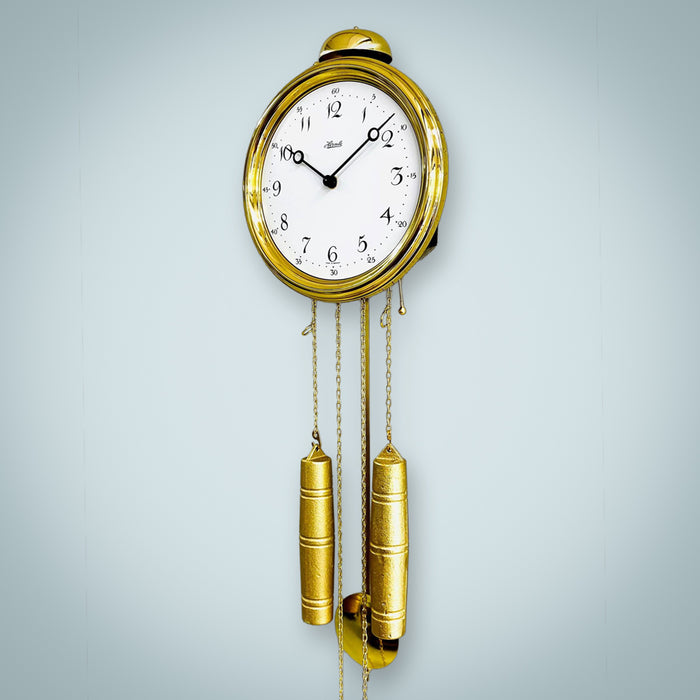 Brass clock hanging on wall