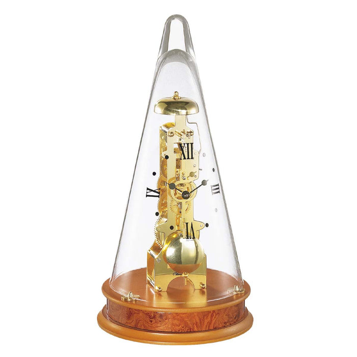 Conical decorative clock with brass gearing visible beneath glass dome, sitting on light cherry wood base