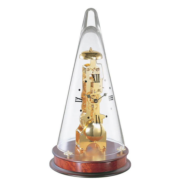 Conical decorative clock with brass gearing visible beneath glass dome, sitting on mahogany wood base