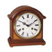 Cherry wood mantel clock with brass highlights and roman numeral face on white background.