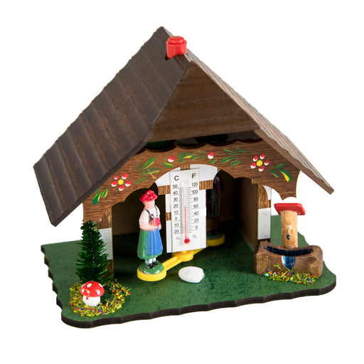 Wooden German style weather station with man and woman figurines on white background.