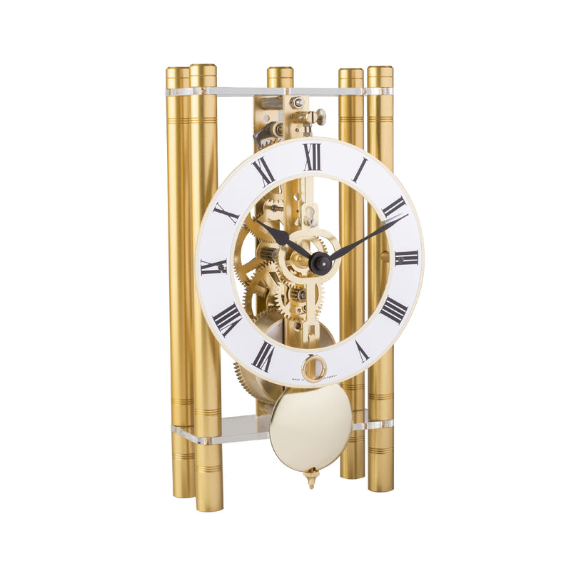 Golden metal clock with roman numerals on the clock face and visible intricate gears.