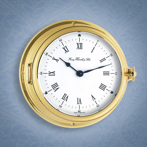 Brass ship's clock on blue wallpaper