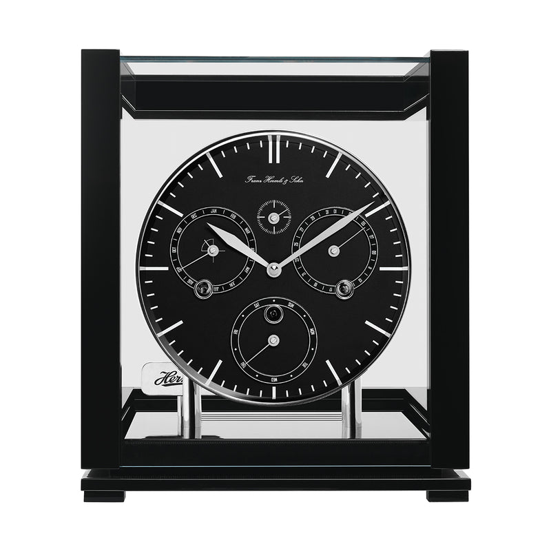 Front view of black perpetual calendar clock with black face and glass panels on white background.