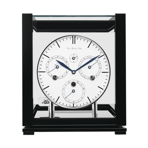 Front view of black perpetual calendar clock with silver highlights and glass panels on white background.